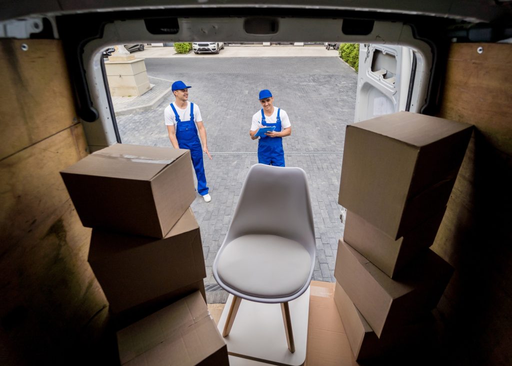 two-removal-company-workers-unloading-boxes-from-minibus