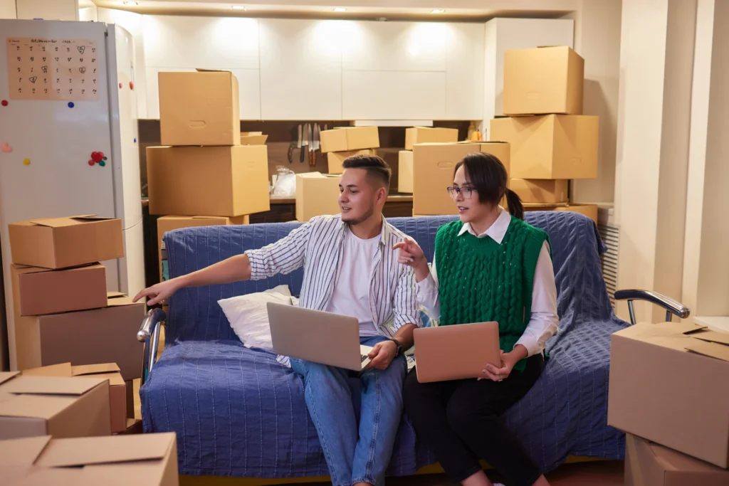 lovely-newlyweds-with-cardboard-boxes-moving-new-apartment-standing-together-kitchen-while-man