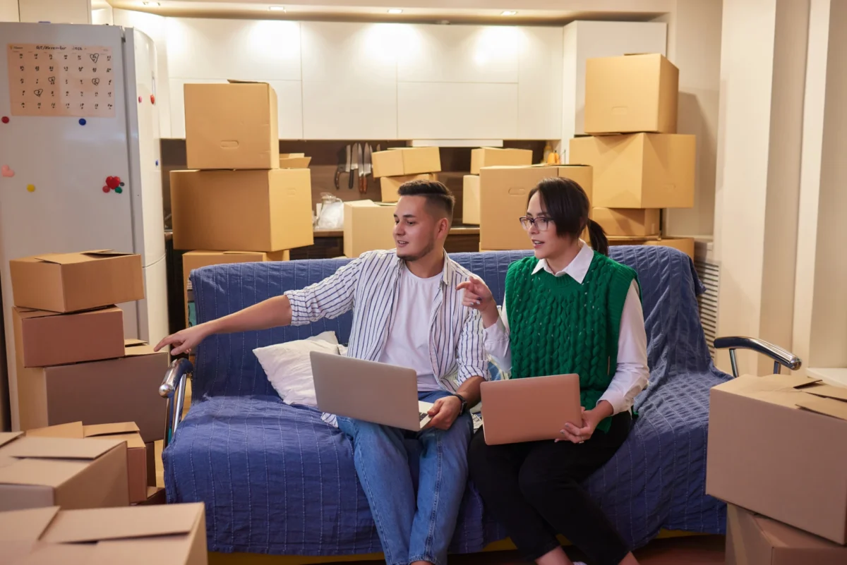 lovely-newlyweds-with-cardboard-boxes-moving-new-apartment-standing-together-kitchen-while-man