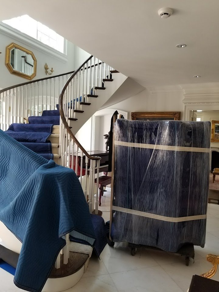 Piano blanket-wrapped on the stairs during an Always Best Moving relocation in Vancouver